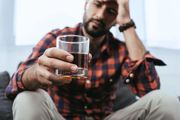 signs of alcohol addiction man suffers with binge drinking and the signs of alcohol addiction